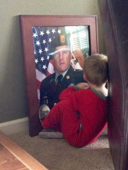 Boy looking at photo of dad killed in action