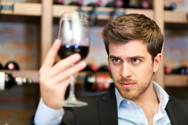 Man looking at a glass of wine